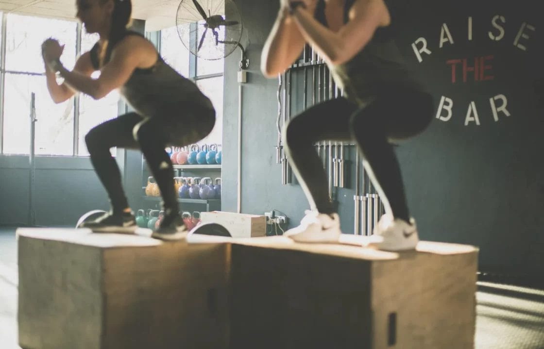 Two women make their work-out wear sweaty by jumping onto boxes